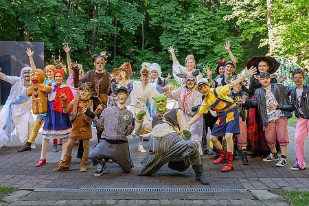 Das Ensemble von „Shrek – Das Musical“ posiert in Märchen- und Tierkostümen vor einer grünen Waldkulisse.