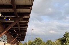 Gäste auf der Terrasse des Weberei-Bahnhofs bei einem sommerlichen Abend mit Getränken und Musik