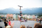Vier Artistinnen und Artisten der Funky Monkeys zeigen eine vertikale Akrobatiknummer vor Publikum und Bergkulisse.