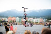 Vier Artistinnen und Artisten der Funky Monkeys zeigen eine vertikale Akrobatiknummer vor Publikum und Bergkulisse.