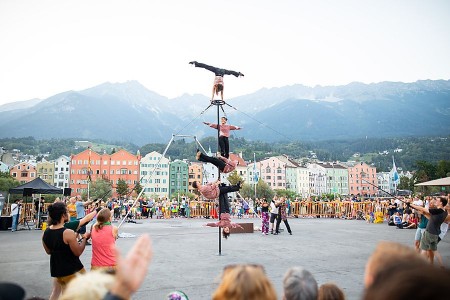 Vier Artistinnen und Artisten der Funky Monkeys zeigen eine vertikale Akrobatiknummer vor Publikum und Bergkulisse.