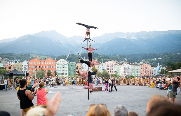 Vier Artistinnen und Artisten der Funky Monkeys zeigen eine vertikale Akrobatiknummer vor Publikum und Bergkulisse.