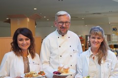 Küchenchef Dirk Fenske steht zwischen den Diätassistentinnen Tatjana Wiens und Nina Halupczok; alle drei halten Teller mit vegetarischen Gerichten in der Cafeteria des Klinikums Gütersloh.