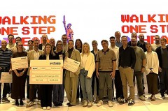 Gruppenfoto der Teilnehmenden der KI-Challenge bei Wortmann mit Preisschecks vor der Präsentationswand „Walking One Step Ahead“.