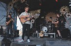 Vier Musiker der Band ETAGE3 spielen mit Gitarren, Bass und Schlagzeug auf einer Bühne.