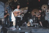 Vier Musiker der Band ETAGE3 spielen mit Gitarren, Bass und Schlagzeug auf einer Bühne.