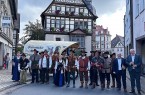 Alt-Text: Historische Schützen in traditionellen Uniformen und Gewändern mit einem Planwagen vor dem Historischen Rathaus in Höxter.
