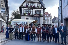 Alt-Text: Historische Schützen in traditionellen Uniformen und Gewändern mit einem Planwagen vor dem Historischen Rathaus in Höxter.