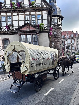 Alt-Text: Historischer Planwagen mit der Aufschrift „Historischer Markt Obermarsberg“ vor dem Historischen Rathaus in Höxter.