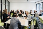 Teilnehmende beim InnovationFestival Bielefeld im Austausch an Gruppentischen auf dem Campus.