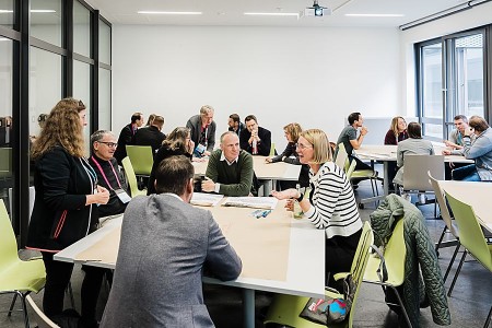 Teilnehmende beim InnovationFestival Bielefeld im Austausch an Gruppentischen auf dem Campus.