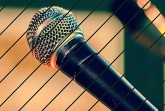 Veranstaltungsplakat zum Life House Poetry Slam mit großem Mikrofon und Angaben zu Termin, Ort und Eintritt.