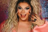 Porträt einer Drag-Performerin in pinkem Outfit mit blondem Haar; im Bild stehen die Schriftzüge „Pam Pengco – Live Comedy Show“ und „Ich entschuldige mich im Voraus!“