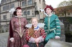 Drei Personen in historischen Renaissance-Kostümen vor Schloss Brake.