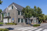Villa Bartels an der Kirchstraße in Gütersloh mit grauer Schieferfassade, weißen Fenstern und grünen Fensterläden