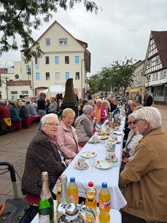 Zahlreiche Gäste sitzen an einer langen gedeckten Tafel beim Vlothoer Bürgerbrunch in der Innenstadt.