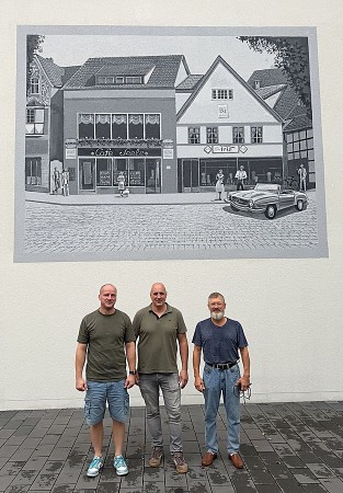 Martin Sommerfeld, Andre Wuttig und Elbrus Sultanov vor dem Wandbild mit einer Straßenszene aus Vlotho in den 1960er-J