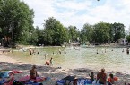 Badegäste und Familien am Ufer des Waldbads Steinhagen an einem sonnigen Sommertag.