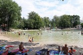 Badegäste und Familien am Ufer des Waldbads Steinhagen an einem sonnigen Sommertag.